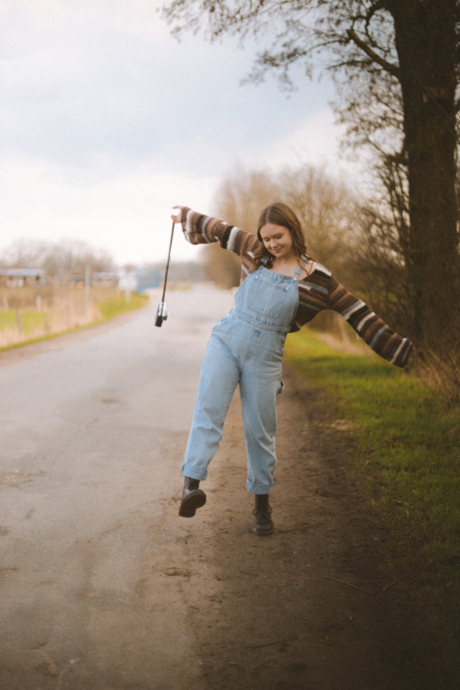 Mila Ziska standing on a dirt road raising her arms