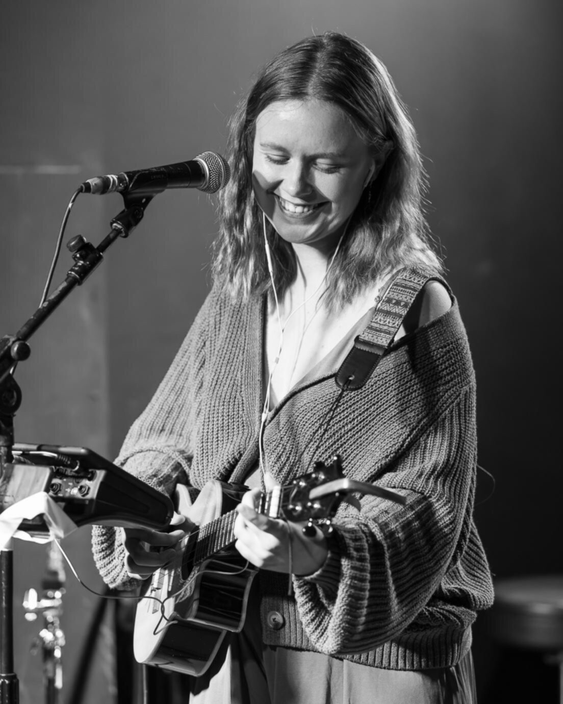 Mila Ziska smiling and playing the ukulele in black and white